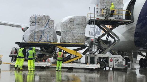 Staff loading shipping pallets on airplane