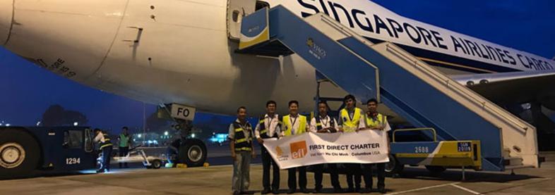 EFL staff holding banner in front of airplane